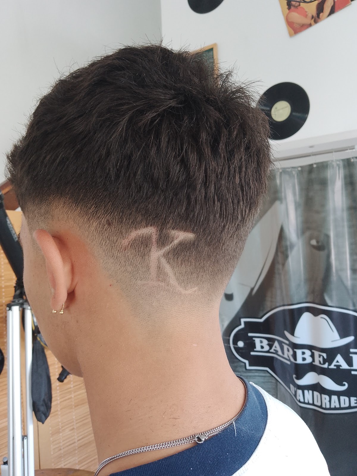 Corte degradê em cabelo cacheado, vista de perfil, na Barbearia D'Andrade