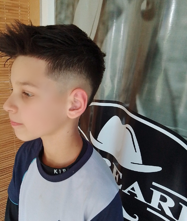 Cliente de perfil com o corte pronto, na Barbearia D'Andrade
